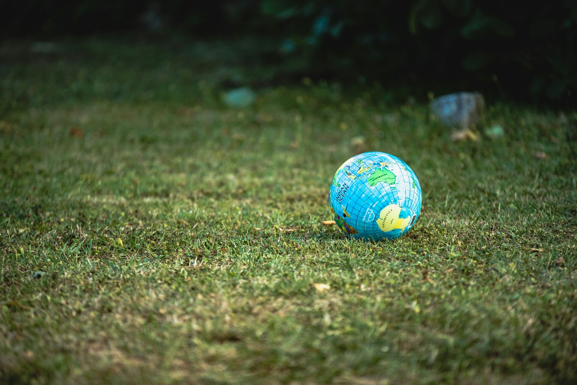 Small inflatable globe resting on sunlit grass